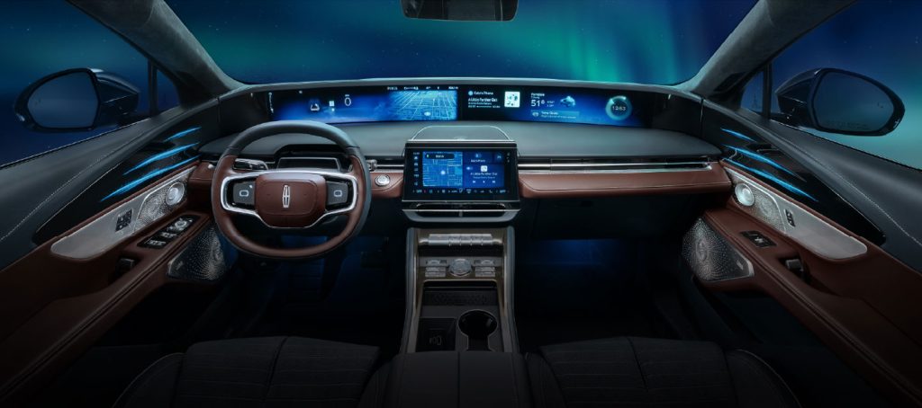 Luxury car interior with panoramic digital dashboard and ambient lighting at night.
