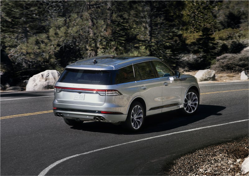A 2023 Lincoln Aviator® Grand Touring model is shown being driven on a tight turn of a mountain road | West Point Lincoln in Houston TX