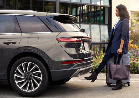 A woman with her hands full uses her foot to activate the available hands-free liftgate. | West Point Lincoln in Houston TX