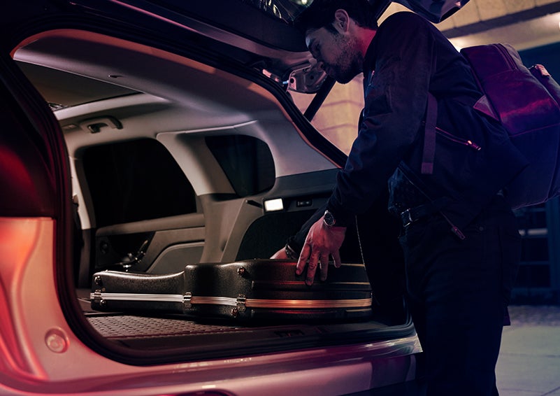 A man is shown loading cargo into the rear of a 2024 Lincoln Corsair® SUV with the second-row seats folded flat. | West Point Lincoln in Houston TX
