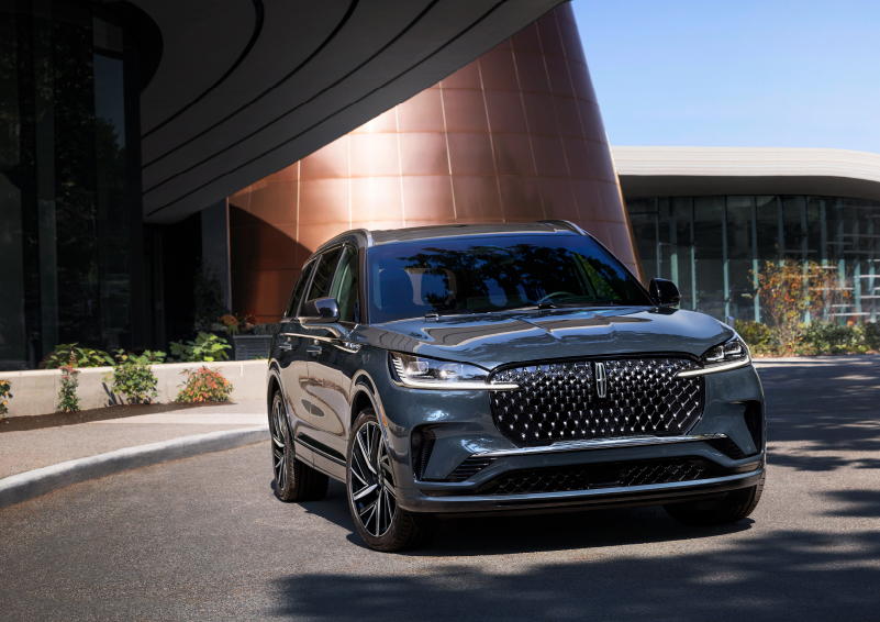A gray 2025 Lincoln Aviator® SUV is parked outside a modern building with the sun shining. | West Point Lincoln in Houston TX