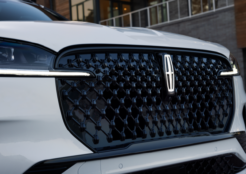 The black grille of a white 2025 Lincoln Aviator® SUV is shown with its fog lights on. | West Point Lincoln in Houston TX