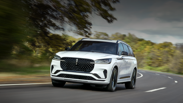 A white 2025 Lincoln Aviator® SUV is being driven down a road lined with trees. | West Point Lincoln in Houston TX