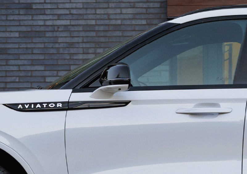 The driver’s side door and fender badging of a white 2026 Lincoln Aviator® SUV are showcased. | West Point Lincoln in Houston TX