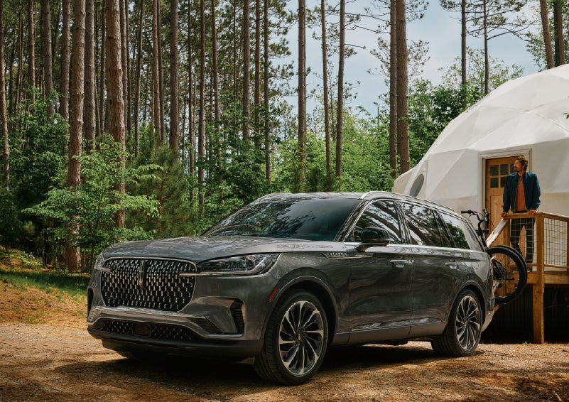 A 2027 Lincoln Aviator® is parked next to a high end glamping site. | West Point Lincoln in Houston TX